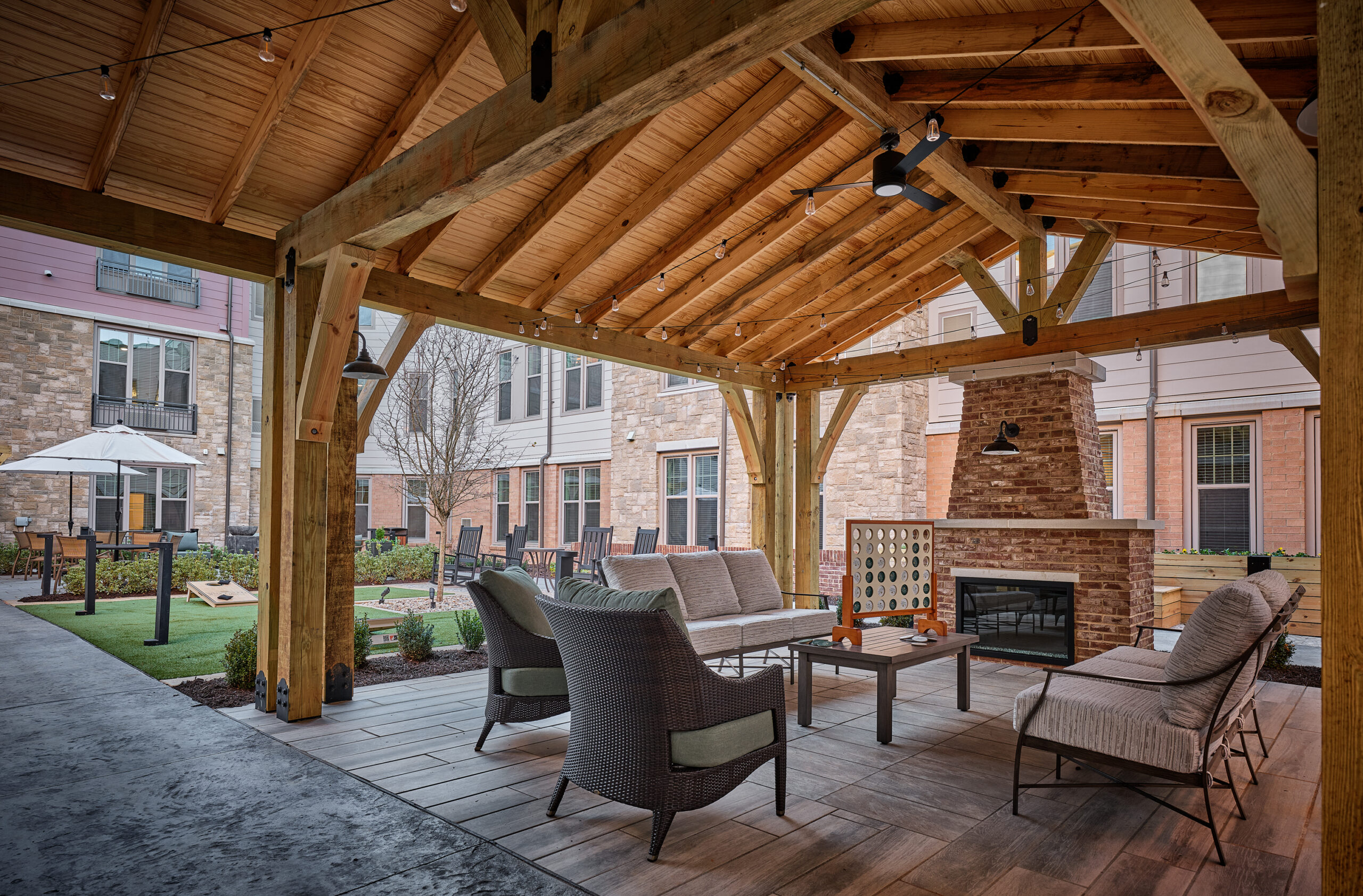 Courtyard at Waltonwood Lead Mine assisted living and memory care community, with a covered seating area, residential-style furnishings, and an outdoor fireplace.