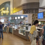 A cozy café at Medford Leas continuing care retirement community, with a neon sign reading 'Fireside' and customers ordering coffee and food.